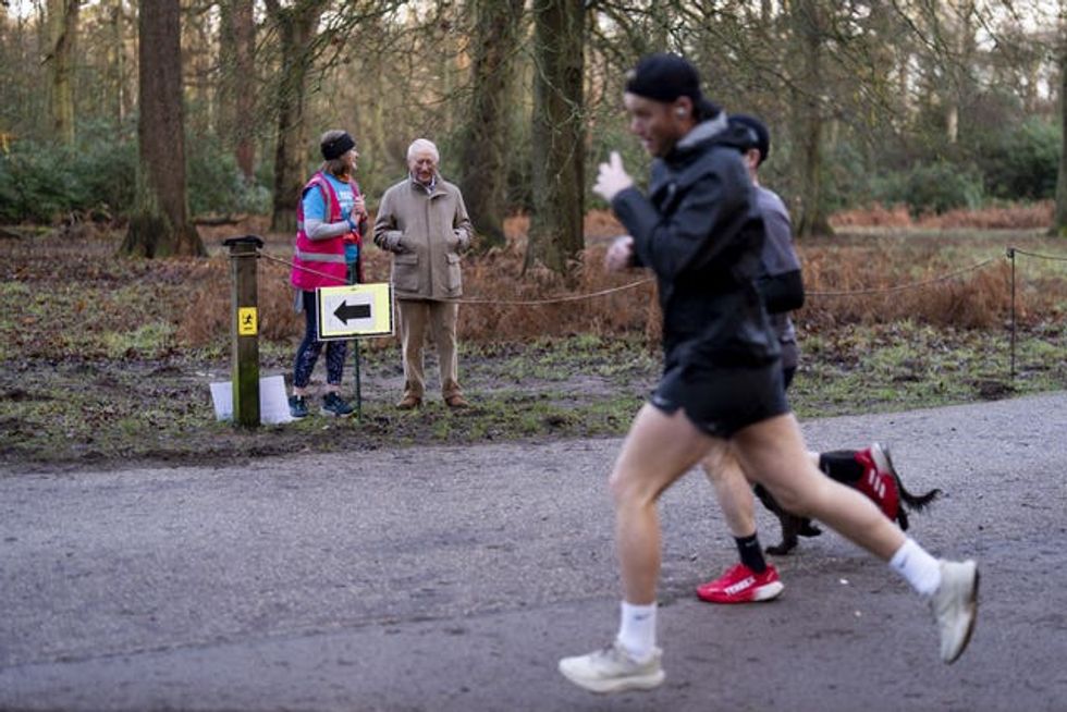 The King and Sarah Byatt at a marshal point as runners pass in the Sandringham parkrun