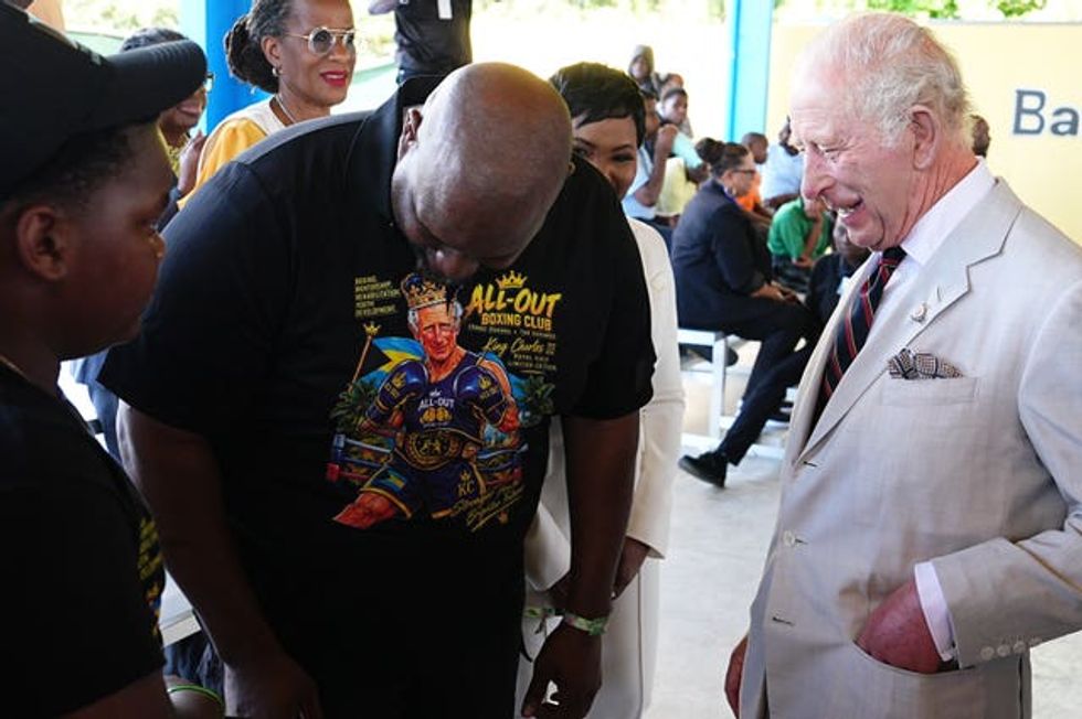 The King meets 12-year-old Sanai Miller and boxing coach Jermaine Gibson during a visit to the Bahamas Boxing Academy in Nassau