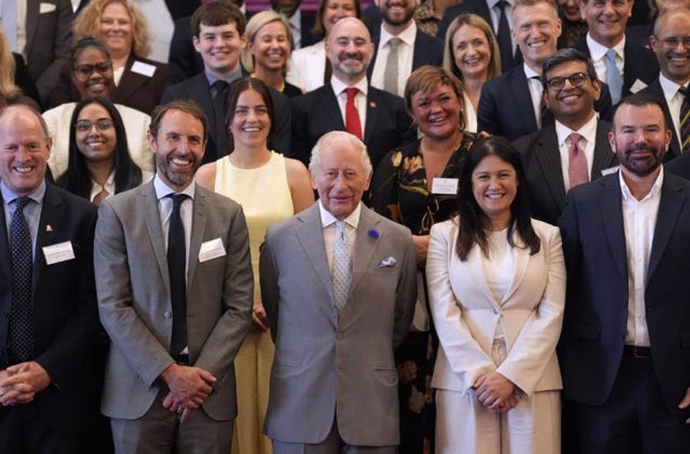 The King, Sir Gareth Southgate and Lisa Nandy smiling at the front of a group photo with a large number of people