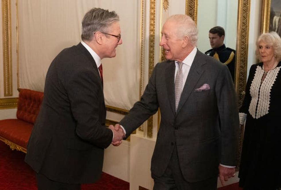 The King smiling and shaking hands with with Prime Minister Sir Keir Starmer at Buckingham Palace