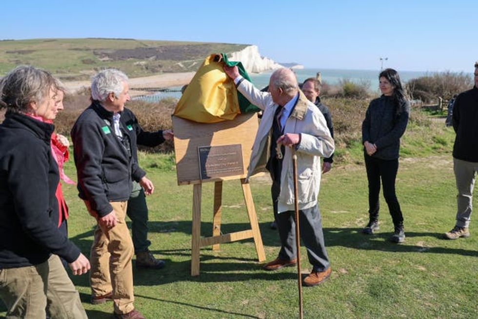 The King unveils a plaque as he inaugurates the Seven Sisters National Nature Reserve in Seaford