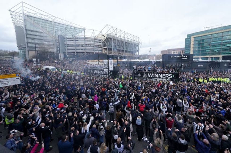The open top buses carrying the Newcastle United players pass by fans outside St James\u2019 Park, during the Carabao Cup trophy parade in Newcastle