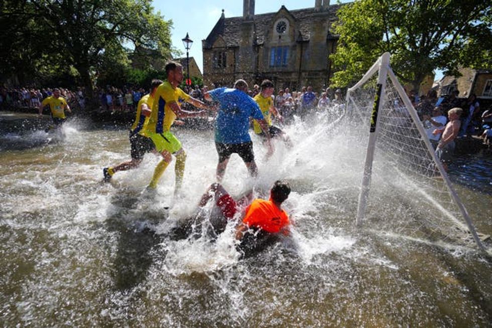 The players created a splash as they fight for the ball (Ben Birchall/PA)