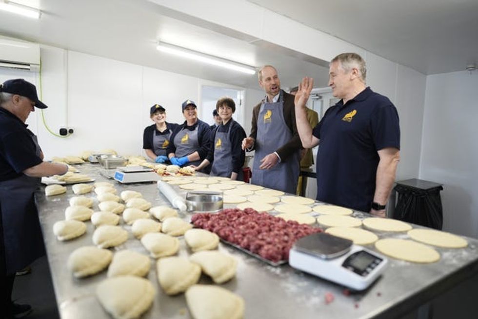 The Prince of Wales is shown how pasties are made during his visit to the Gear Farm Pasty Company