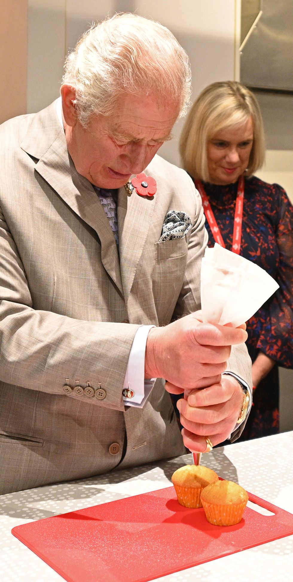 The Prince of Wales tries his hand at decorating cupcakes (Oli Scarff/PA)