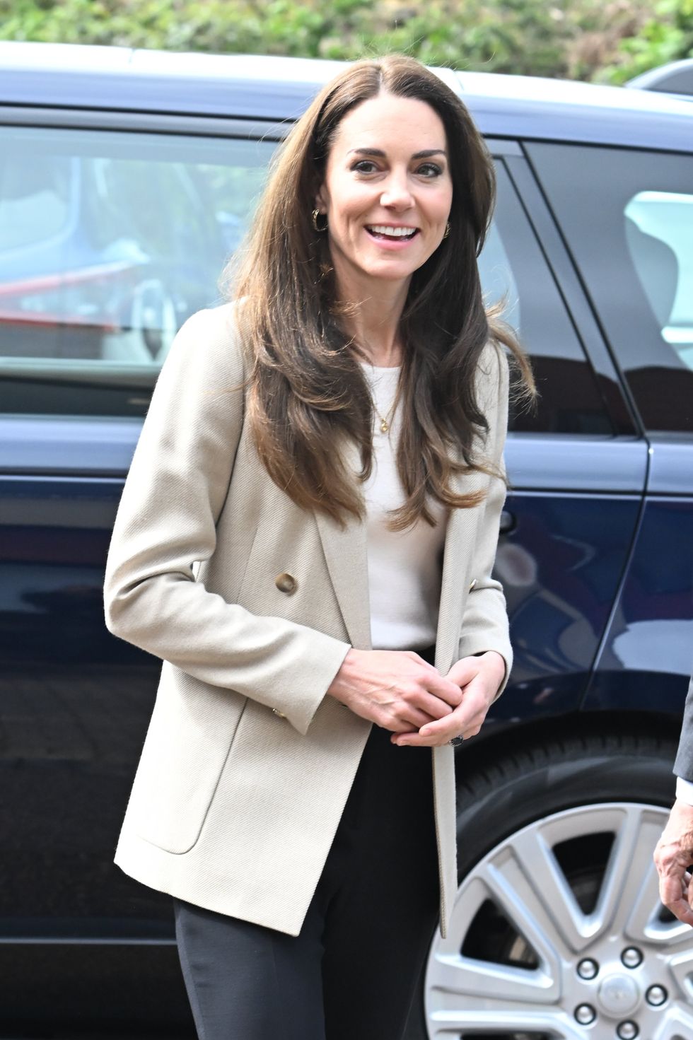 Kate helps fold baby clothes on visit to Baby Bank donation centre