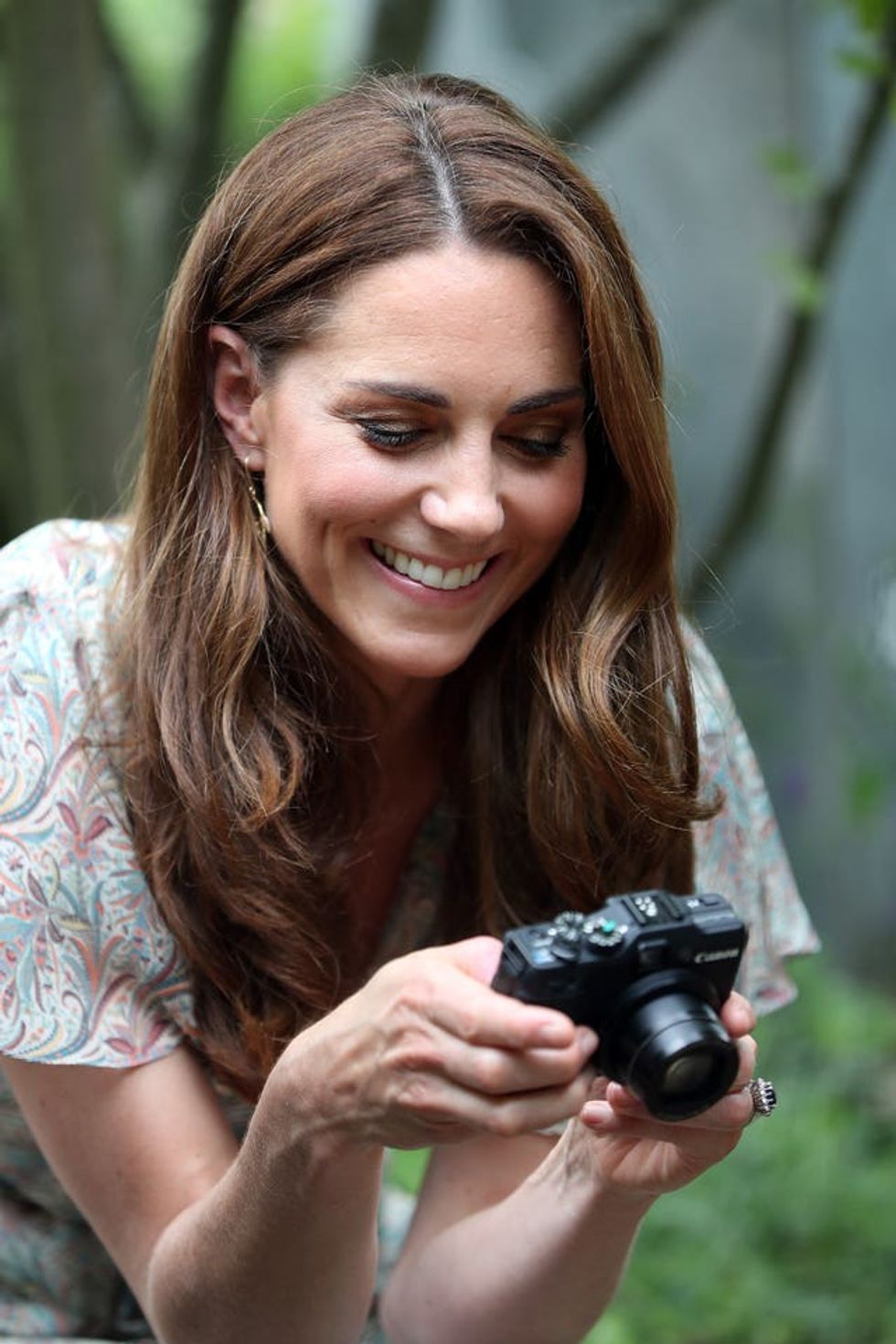 The Princess of Wales smiles while holding a camera