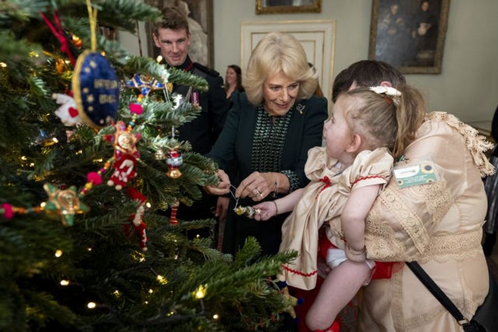 The Queen and Dolce place a decoration on the Christmas tree at Clarence House