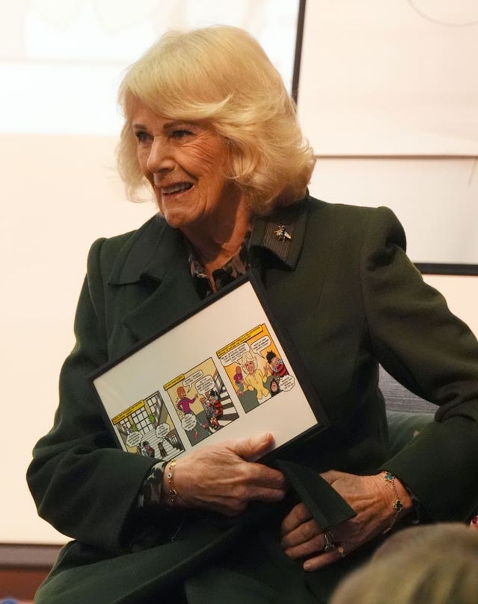 The Queen holds the framed Beano comic strip featuring herself which was presented to her during a visit to the National Library of Scotland