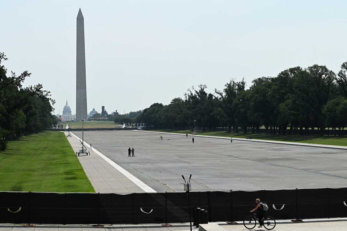 The Reflecting Pool in Washington, D.C., showing fencing and black tarpaulin in the foreground, and the drained pool and Washington Monument in the background.