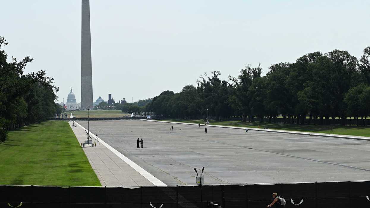 The Reflecting Pool in Washington, D.C., showing fencing and black tarpaulin in the foreground, and the drained pool and Washington Monument in the background.