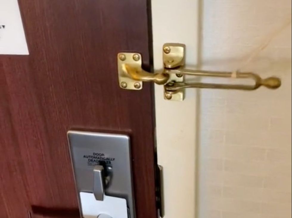 The rubber band yanks open the hotel lock, unlatching it completely.