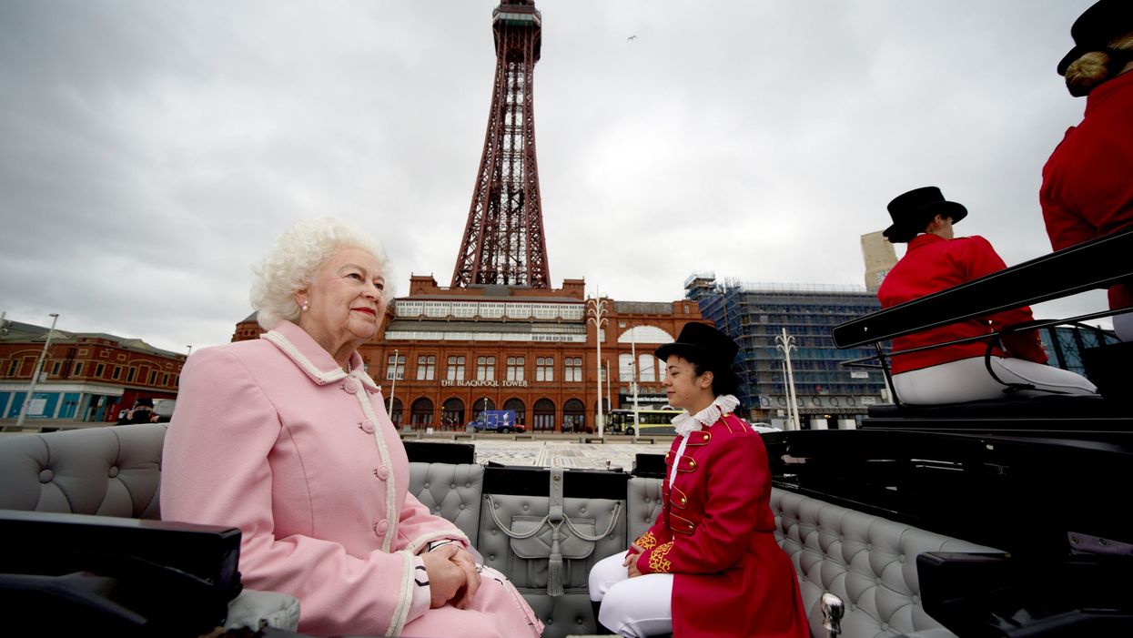 The wax figure of the Queen is driven along Blackpool’s seafront in a horse and carriage along the seafront as it makes its way to Madame Tussauds (Peter Byrne/PA)
