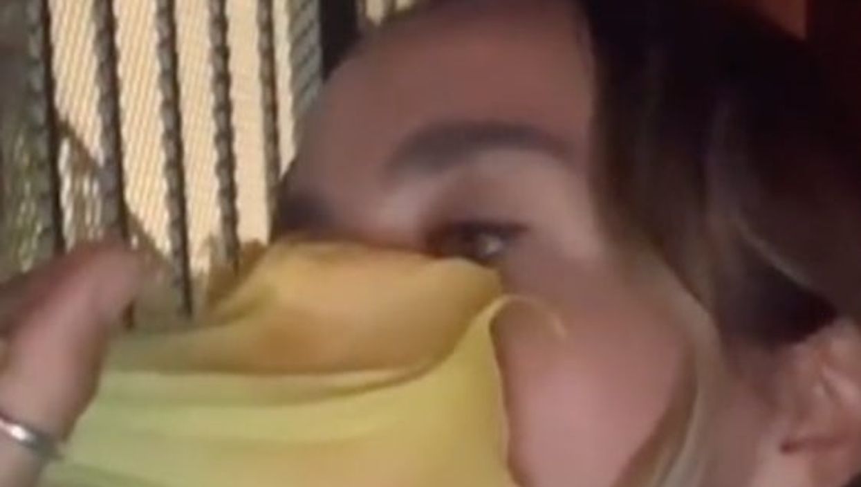 <p>The woman takes a deep huff of the bright yellow flower</p>