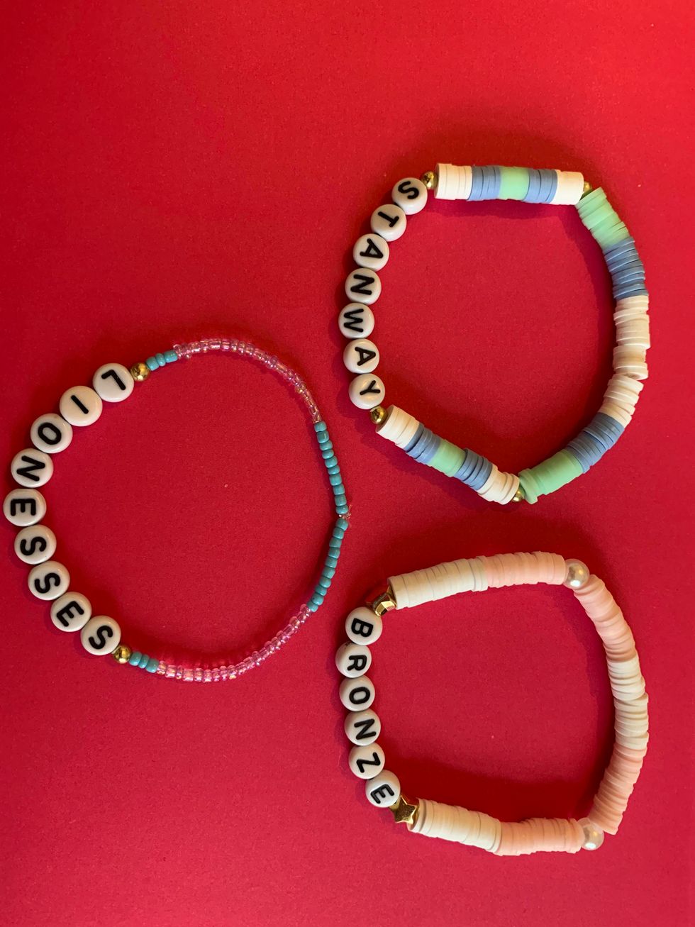 Three bracelets with letters reading Lionesses, Stanway and Bronze