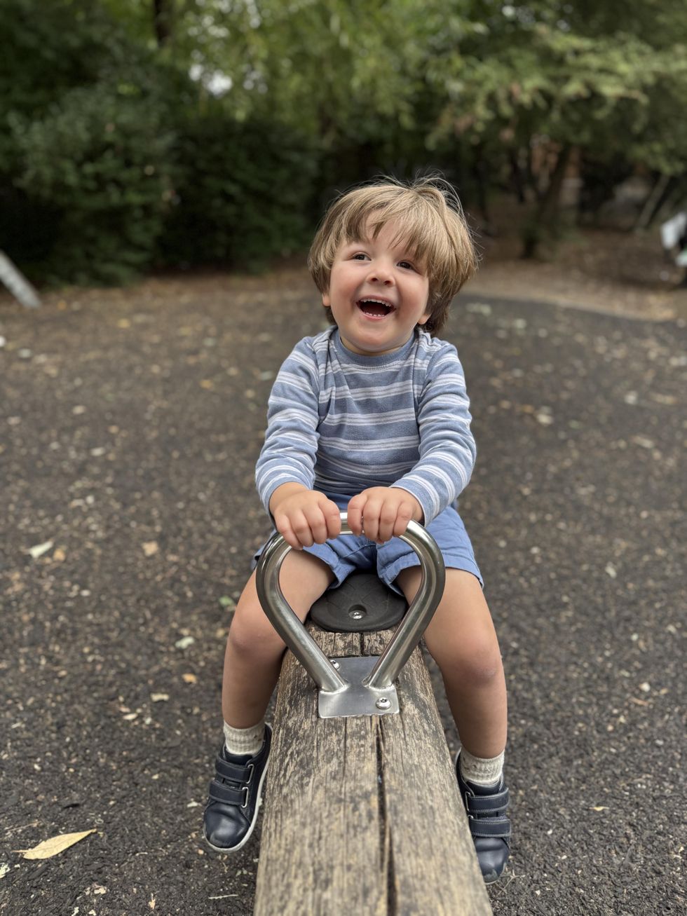 Three-year-old Nathaniel Clayton smiling on a see-saw