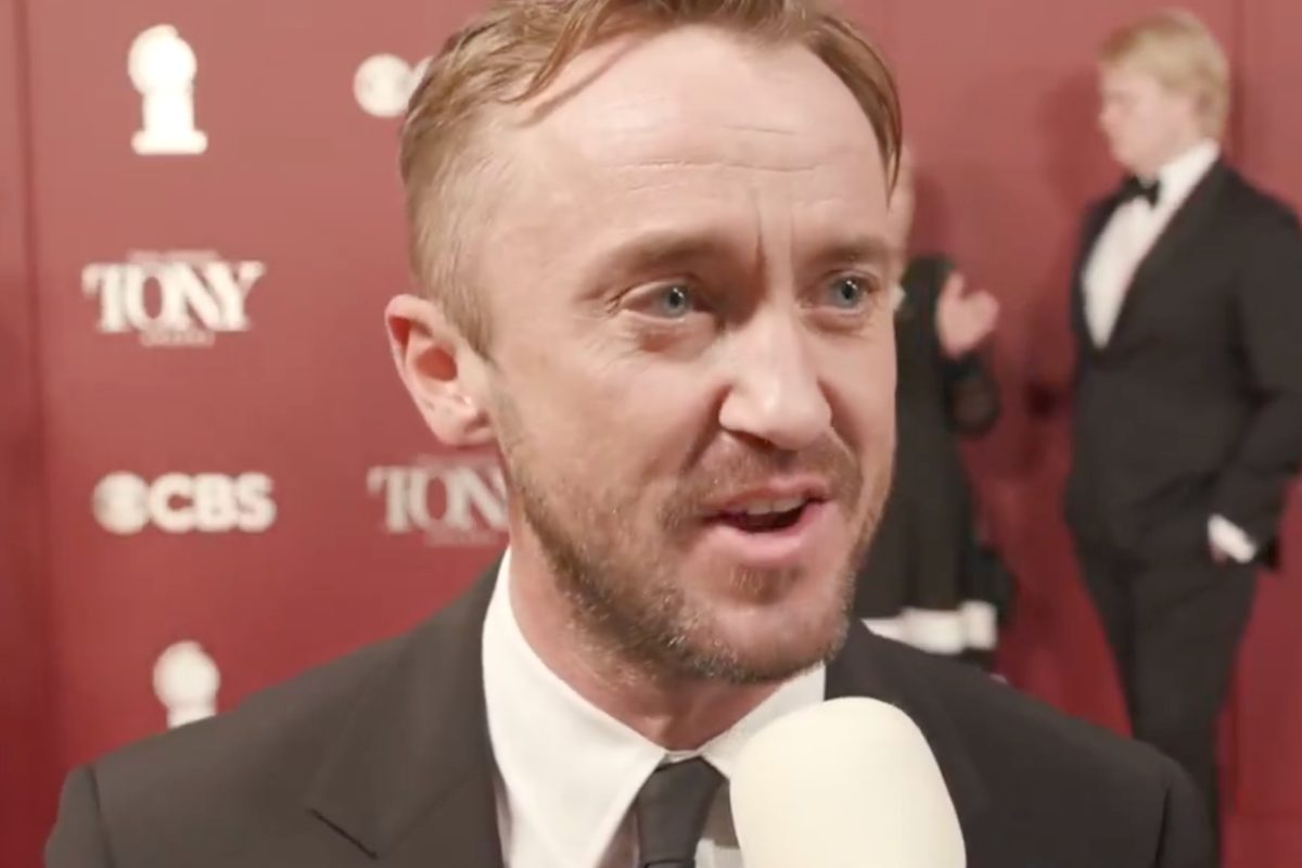 Tom Felton in a black suit, speaking to Variety on the red carpet at the Tony Awards.