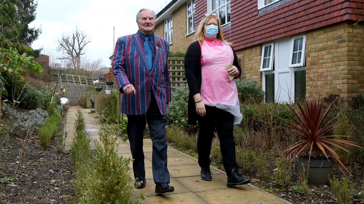 Tom Jones, 103, walks laps of the garden at his care home in Bexleyheath, Kent, with activity co-ordinator Debbie Rutty
