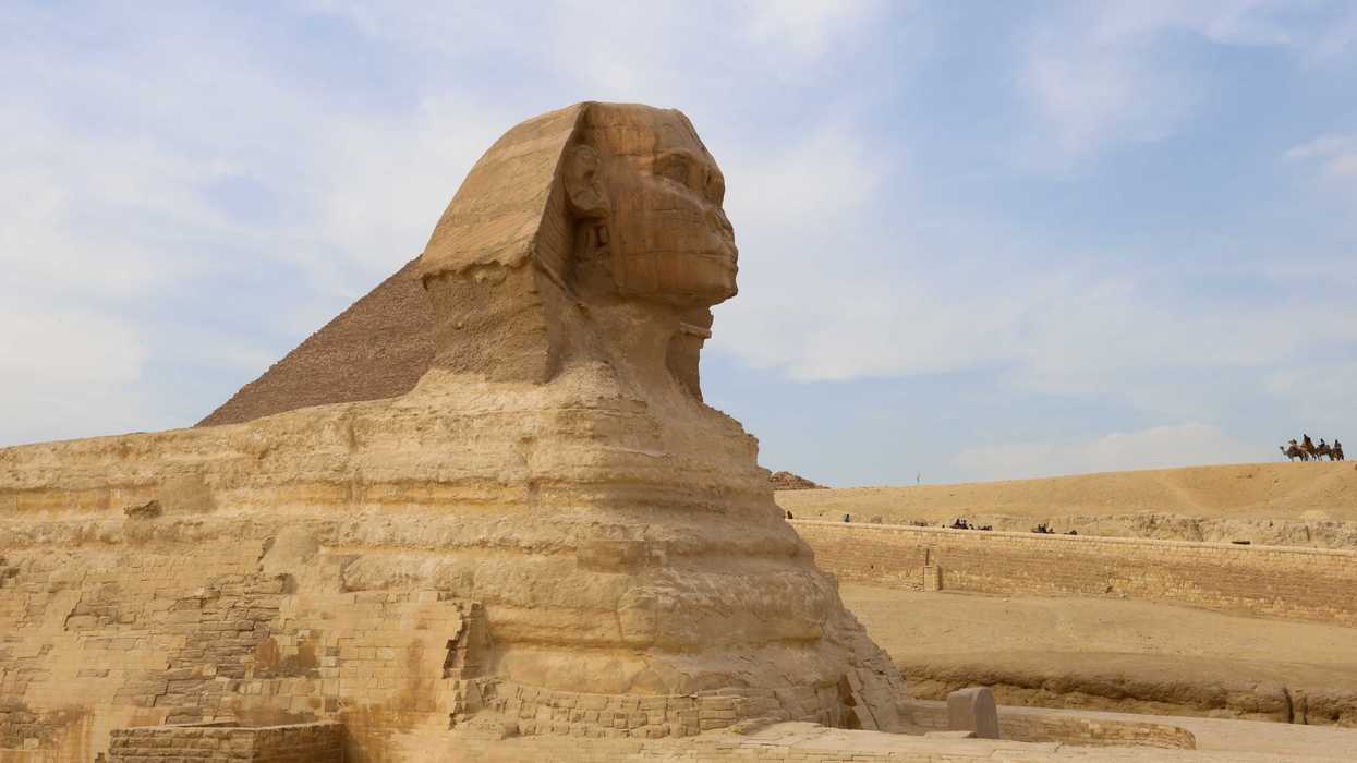 Tourists ride camels near the Sphinx and the Pyramid of Khafre or Chephren, a UNESCO World Heritage site, in Giza on the outskirts of Cairo, Egypt, on February 25, 2025