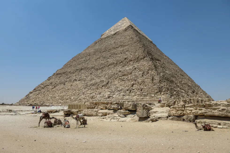 Tourists walk past the pyramids of Khufu, Khafre, and Menkaure on July 21, 2024 in Giza, Egypt
