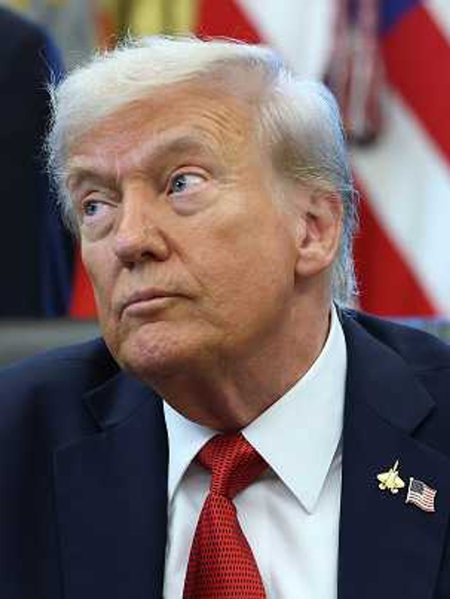 Trump in the Oval Office, looking to his right with raised eyebrows.