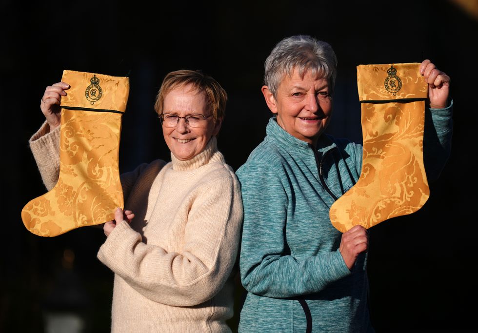 Two women hold up Christmas stockings