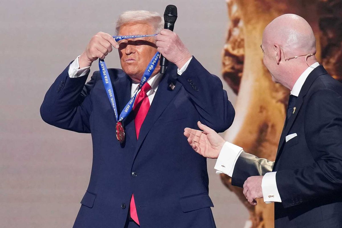 U.S. President Donald Trump places the FIFA Peace Prize around his neck after receiving it from FIFA President Gianni Infantino (R) at the FIFA World Cup 2026 Official Draw at the John F. Kennedy Center