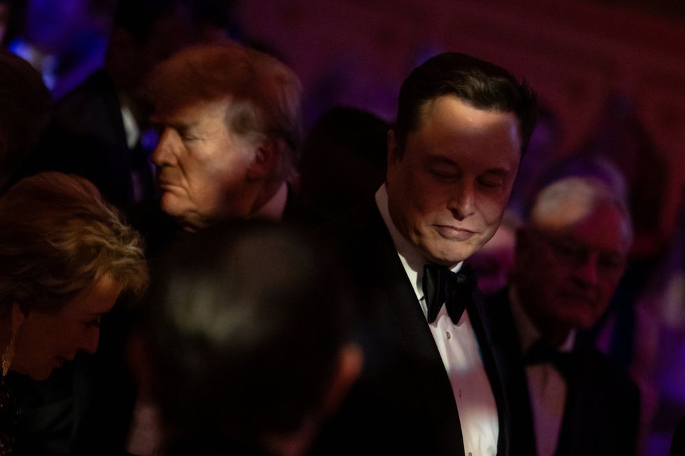U.S. President-elect Donald Trump walks by Elon Musk during the America First Policy Institute (AFPI) gala at Mar-A-Lago in Palm Beach, Florida, U.S., November 14, 2024