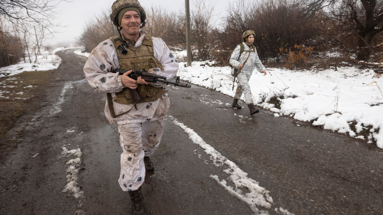<p>Ukrainian soldiers walks at the line of separation from pro-Russian rebels near Katerinivka, Donetsk region, Ukraine (Andriy Dubchak/AP)</p>