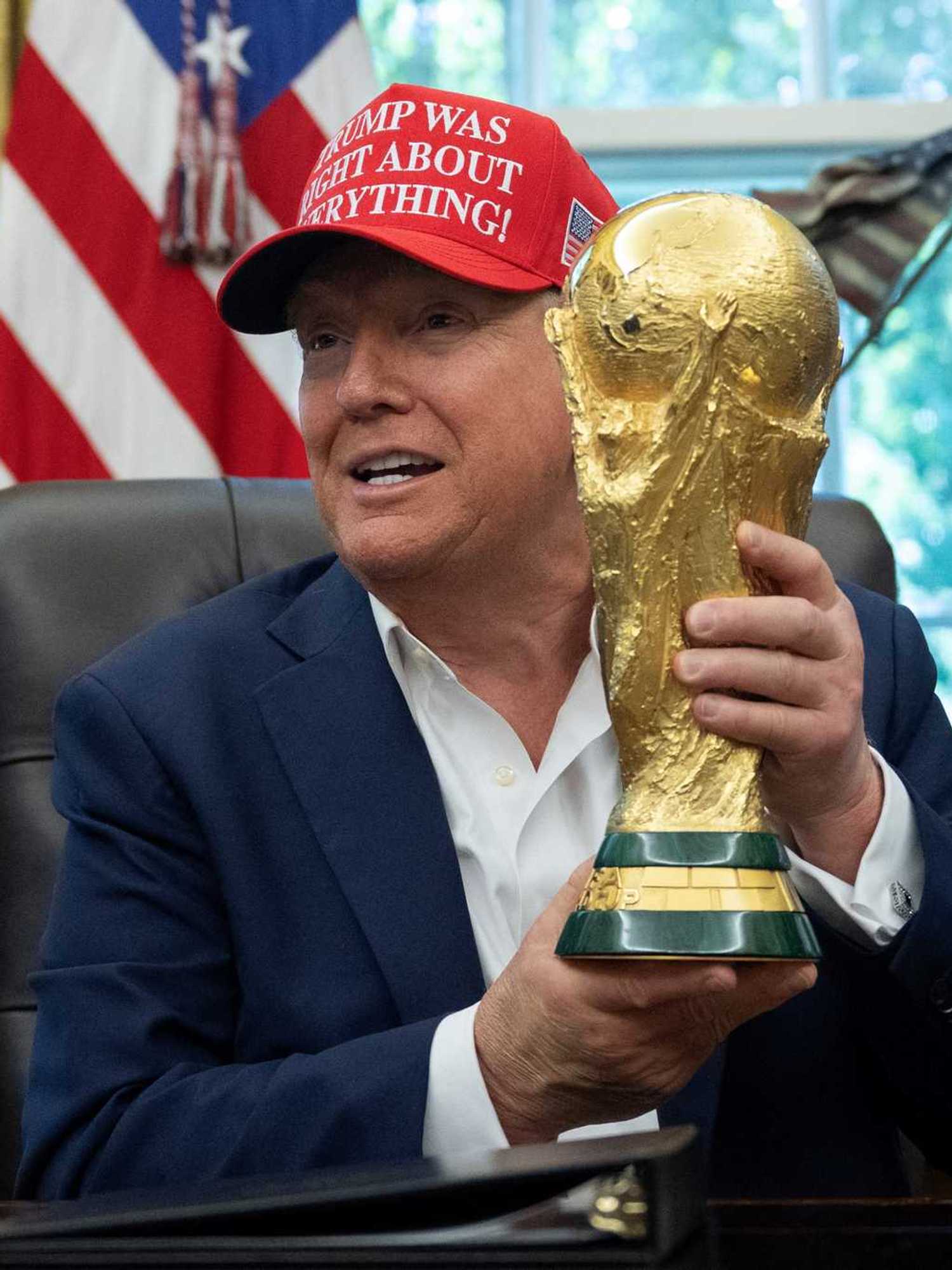 US President Donald Trump holds the World Cup trophy in the Oval Office of the White House in Washington, DC, on August 22, 2025