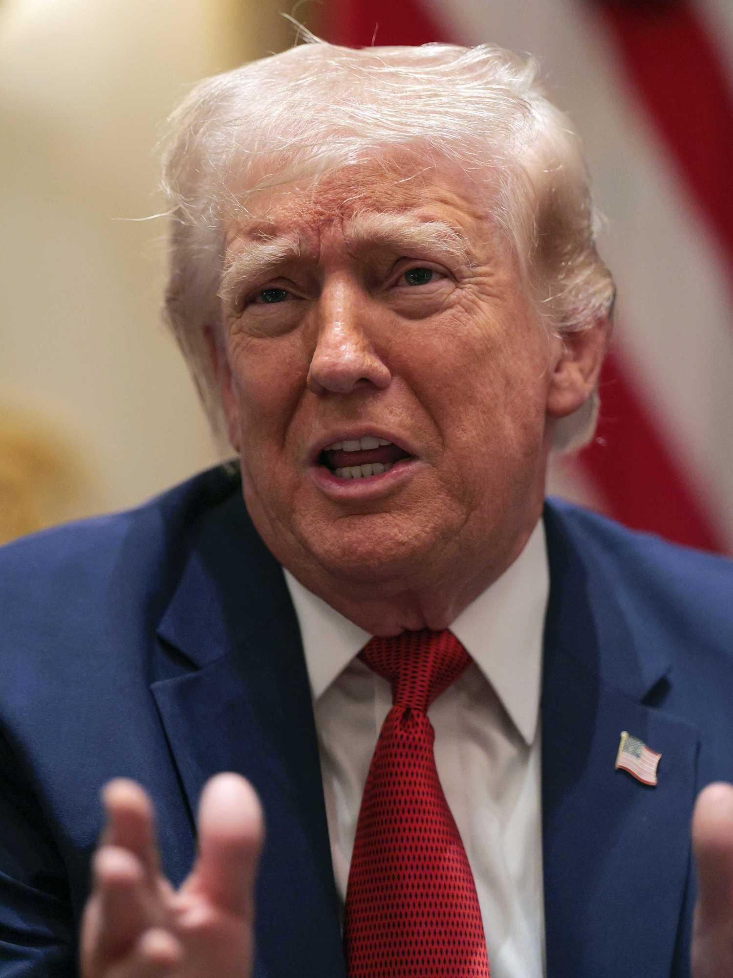 US president Donald Trump sits in a chair and speaks inside the White House.