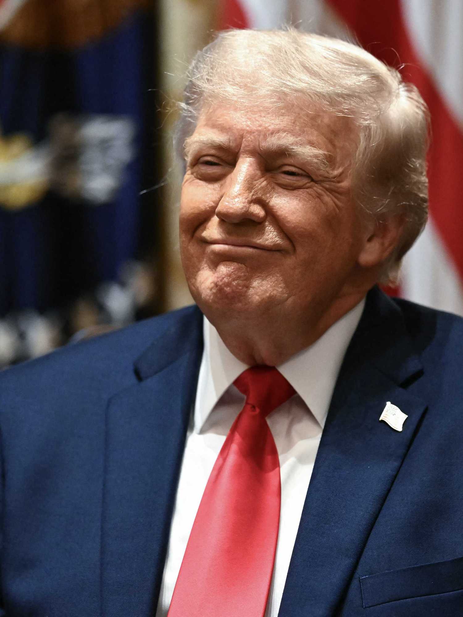 US president Donald Trump smiles smugly while sitting in the Cabinet Room of the White House.