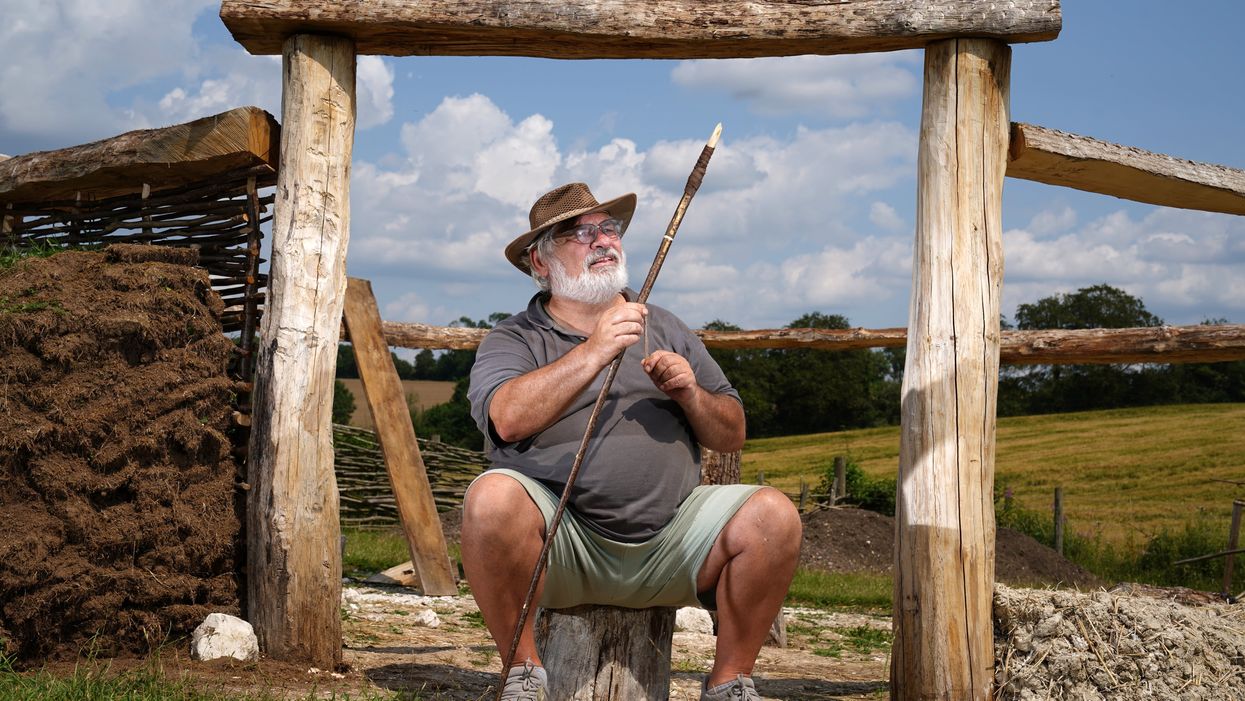 <p>Veteran Kevin Reilly helps with work on a Bronze Age roundhouse (Andrew Matthews/PA)</p>