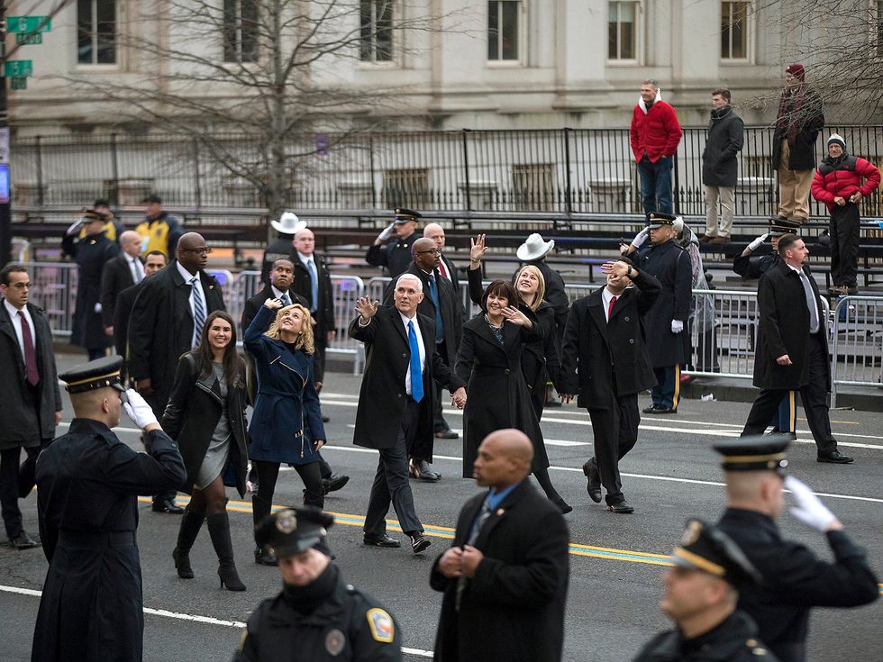 Vice President Mike Pence waves as he and his family walk during the inauguration parade in Washington, past nearly empty bleacher seats next to the Treasury Department