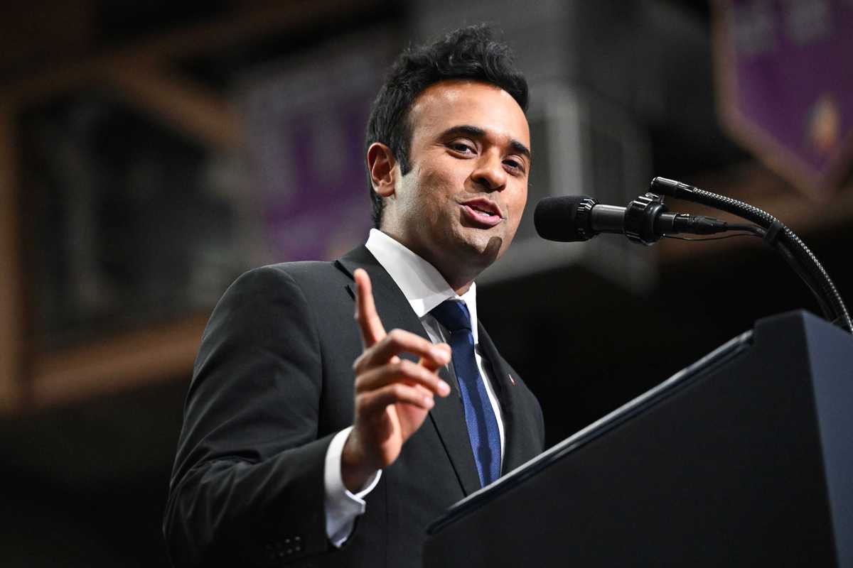 Vivek Ramaswamy speaking into a microphone while standing behind a lectern.