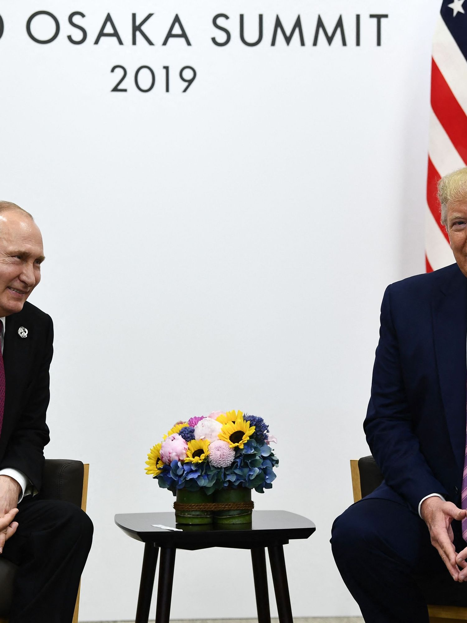 Vladimir Putin, left and smiling, sits opposite Donald Trump, right, also smiling, at the G20 Osaka Summit 2019.