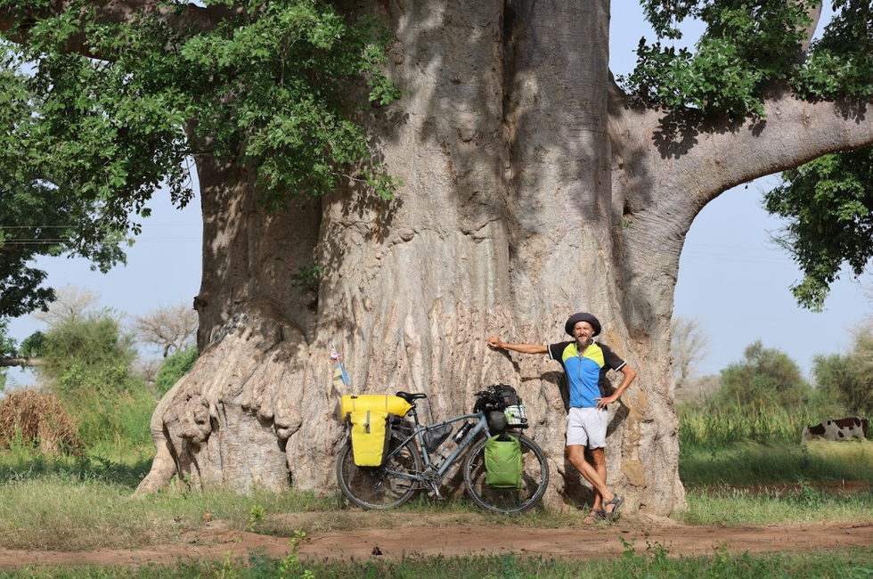 Volodymyr Muliar pictured in front of a huge tree in Senegal as part of a cycling adventure