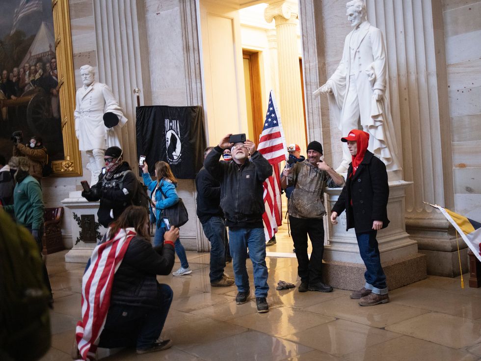 WASHINGTON, DC - JANUARY 06: Protesters supporting U.S. President Donald Trump gather gather in the Rotunda of the U.S. Capitol after groups breached the building\u2019s security on January 06, 2021 in Washington, DC. Pro-Trump protesters entered the U.S. Capitol building during demonstrations in the nation\u2019s capital.  (Photo by Win McNamee/Getty Images)