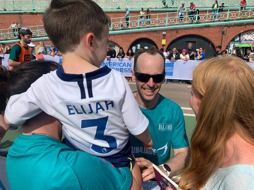 Wayne Flanagan greeting well-wishers including son Elijah, five, during the Brighton Marathon on September 12 (Family handout/PA)