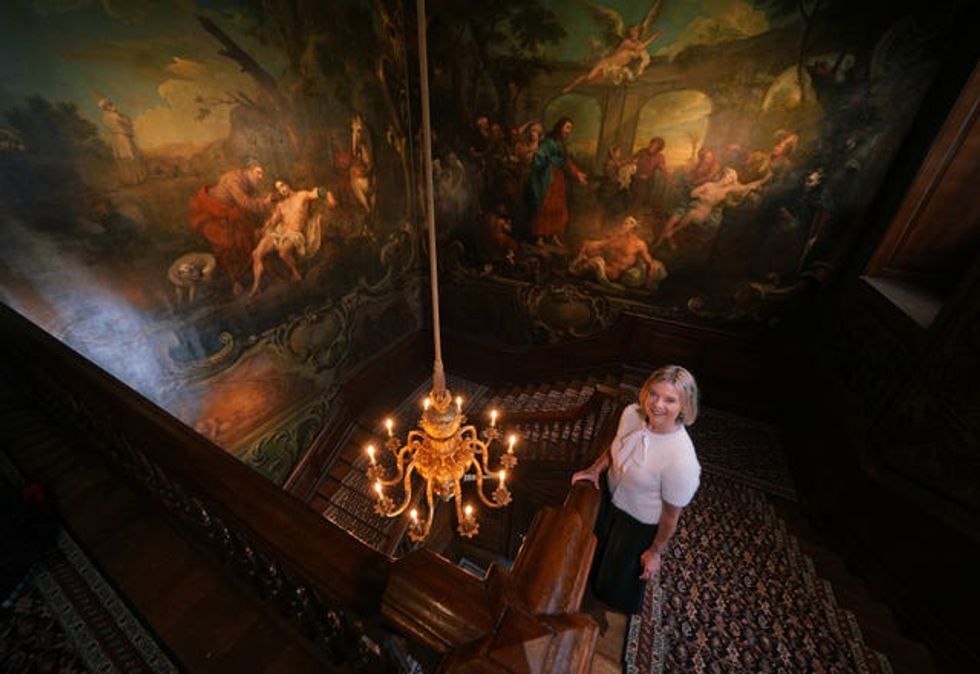 Wendy Porter, a nurse at the hospital, stands in the Grand Staircase, which is decorated with large-scale history paintings by William Hogarth, The Good Samaritan (left) and The Pool of Bethesda (1735-1737), during a preview of the new North Wing of St Bartholomew\u2019s Hospital in West Smithfield, central London