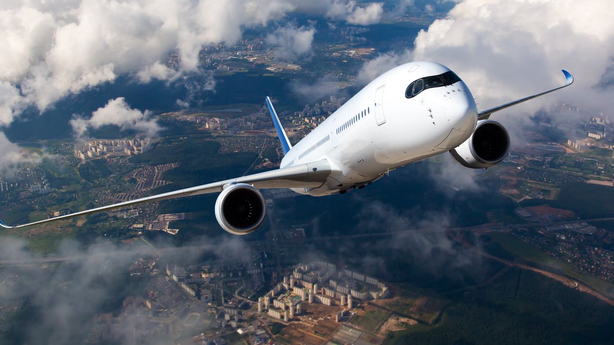 <p>White passenger plane climbs through the clouds. Aircraft is flying high above the city.</p>