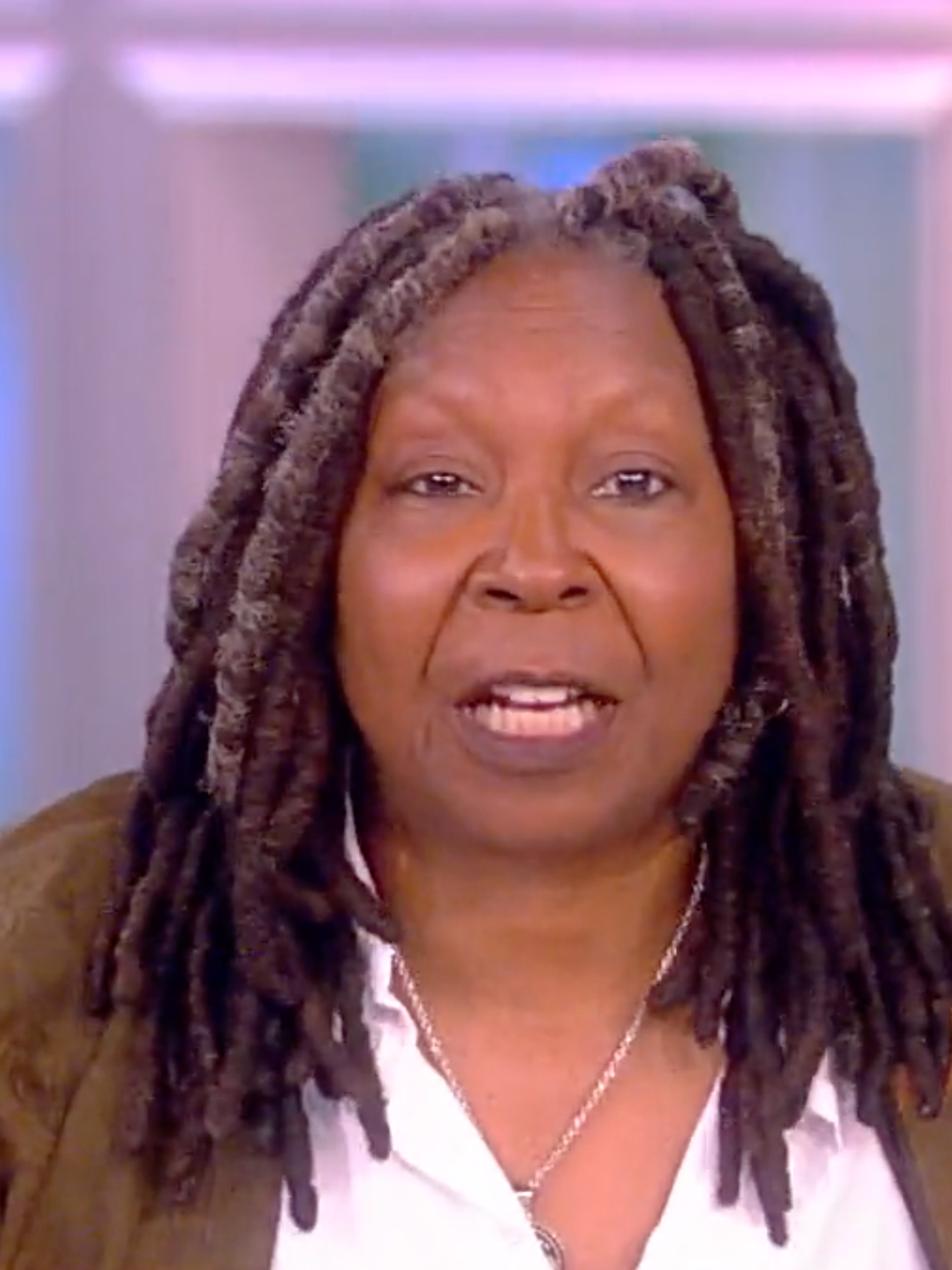 Whoopi Goldberg, a Black woman with brown hair in dreadlocks, talks to the camera during an episode of The View.