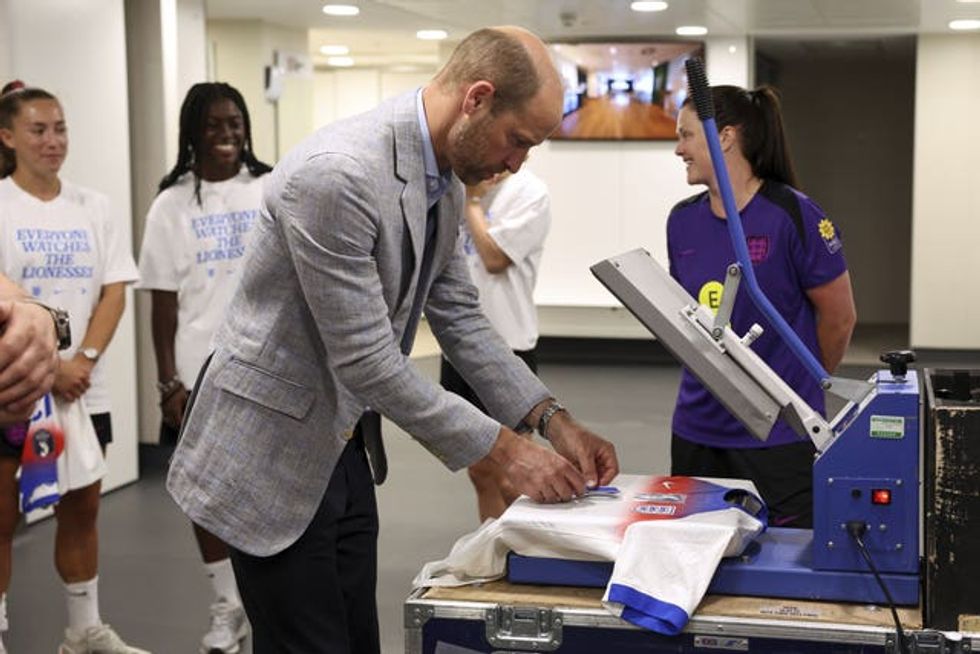William adds finishing touches to a t-shirt on a heat press