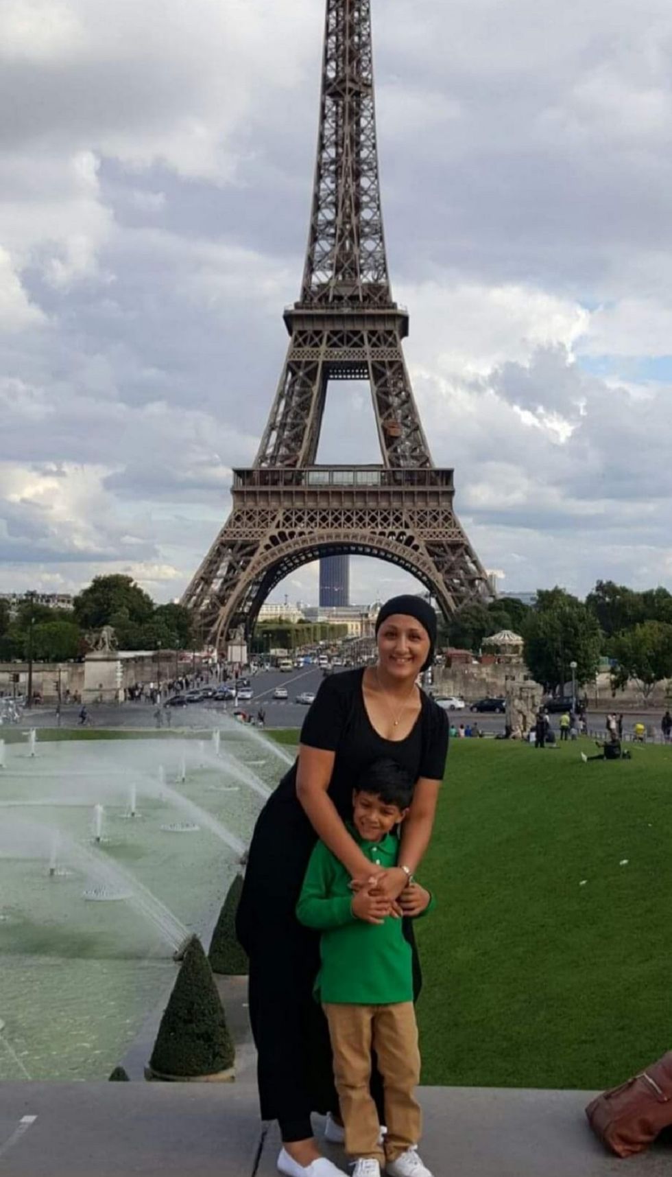 Woman and boy looking at the camera with the Eiffel Tower in the background