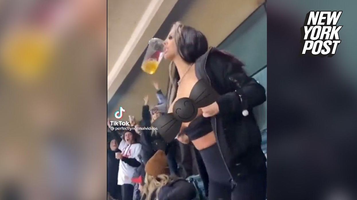Rugby fan flashes breasts at cameras during live news report