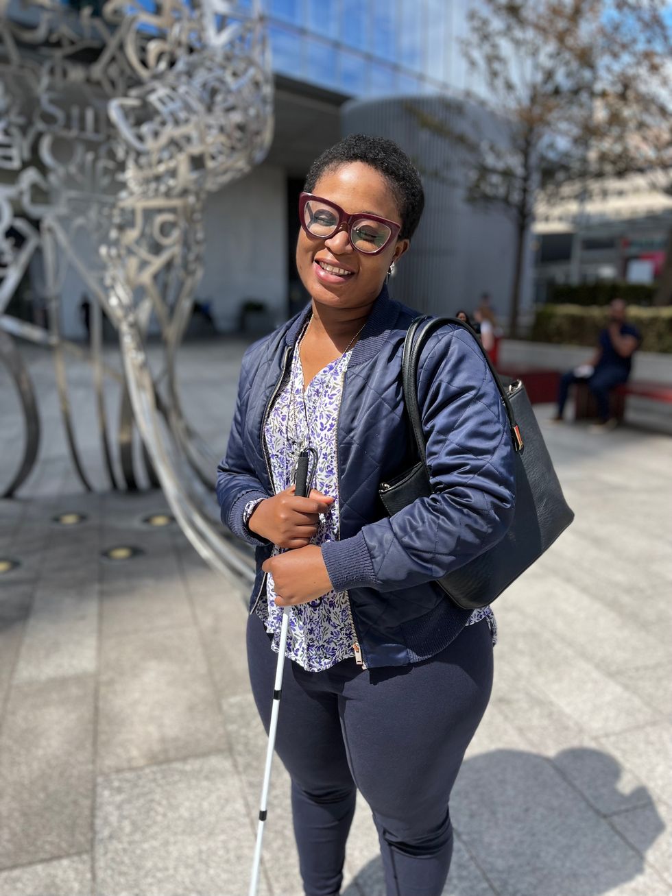 Woman holding a cane and looking at the camera