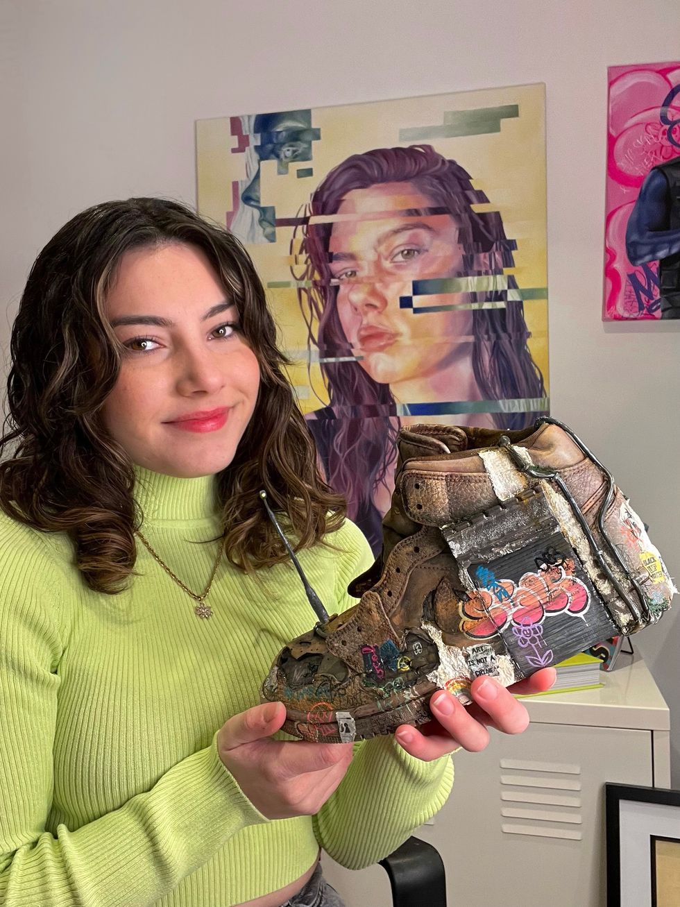 Woman holds painted sneaker created by her