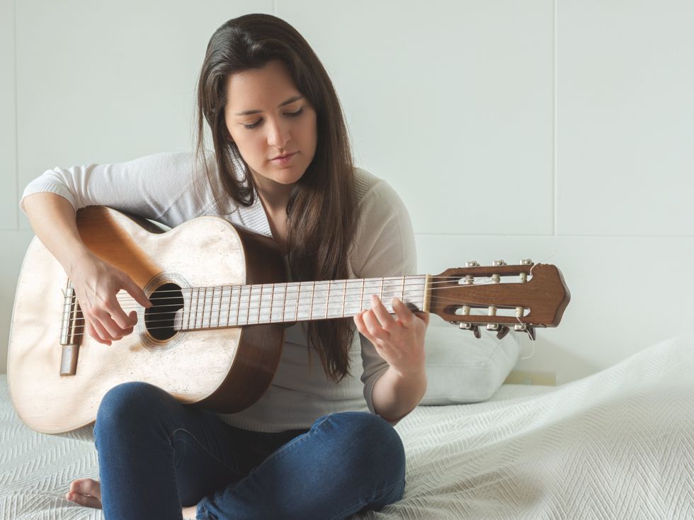 Woman playing the guitar.