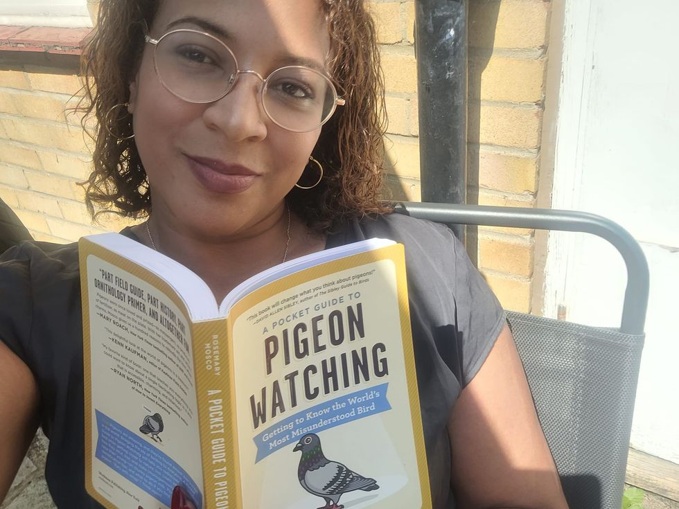 Woman smiling at the camera and holding a book