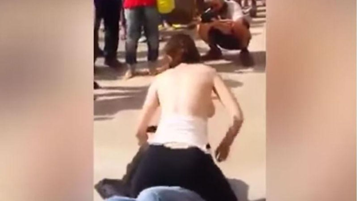 woman with her shirt off slapping man before rubbing bare breasts in his face